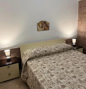 um quarto com uma cama com duas mesas de cabeceira e dois candeeiros em La Rizzaia casa indipendente em Trapani