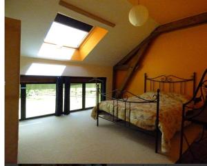 a bedroom with a bed and a skylight at Gite Loft 3 étoiles in Tresnay