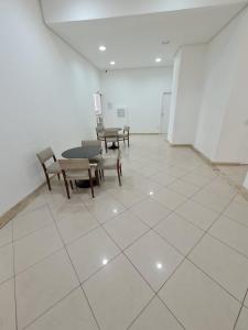 a room with a table and chairs on a tiled floor at Apartamento quarto/sala, Garibaldi Prime in Salvador