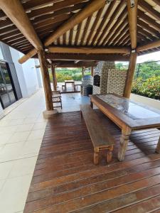 a wooden deck with a table and a bench on it at Apartamento quarto/sala, Garibaldi Prime in Salvador