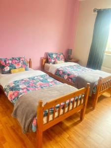 a bedroom with two beds and a couch at Ballytigue House in Droíchead an Chláir