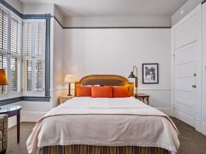 a bedroom with a large bed with orange pillows at The Upham Hotel in Santa Barbara