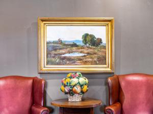 a painting of a field with a vase of fruit on a table at The Upham Hotel in Santa Barbara