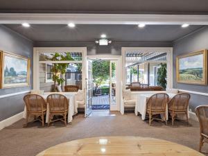 聖巴巴拉的住宿－阿珀姆酒店，一间设有白色桌椅的用餐室