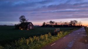 阿姆斯特丹的住宿－GuestHouse Amsterdam "City Farmer" lodge with a skyline view in the countryside，公路旁田野中间的房子