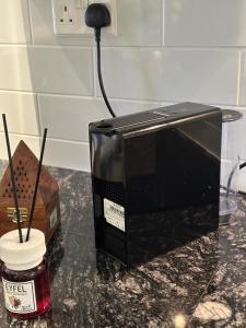 a microwave sitting on a counter next to a jar of jam at Sifah Ocean Breeze Villa in Muscat