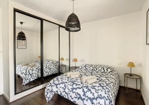 a bedroom with a bed and a mirror at Appartement Biarritz Saint Charles in Biarritz