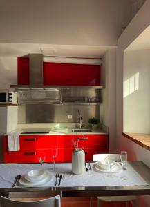 佩德尼亞的住宿－Bahía de Pedreña 2，厨房配有红色橱柜和酒杯桌子
