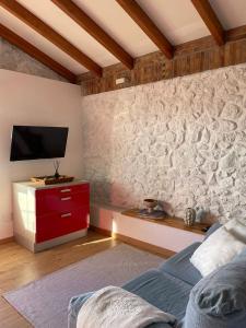佩德尼亞的住宿－Bahía de Pedreña 2，一间卧室设有一面墙壁,其中配有电视