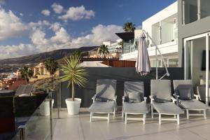 a group of chairs sitting on top of a balcony at Azure Sky Villa - Panoramic ocean view, luxury, San Eugenio in Adeje
