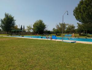 a large swimming pool with people in a park at El laurel y el limonero. in Las Pajanosas