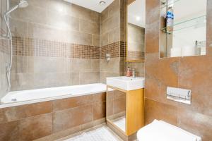 a bathroom with a tub and a sink and a toilet at Dreamwise apartment in Woolwich