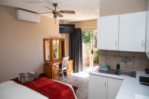 a bedroom with a bed and a kitchen with a sink at Cosy - Best Rest Potch in Potchefstroom