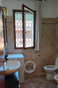 een badkamer met een toilet, een wastafel en een raam bij La casa del Sole a Cesena in Cesena