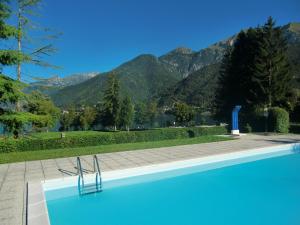 una piscina con montañas en el fondo en Appartamento Aila, en Molina di Ledro