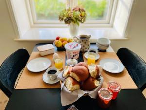 a table with a breakfast of bread and orange juice at Strandby 1847 B&B in Nykøbing Falster