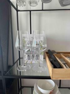 dois copos de vinho em cima de uma mesa de vidro em Studio 25m indépendant Tour Eiffel em Paris