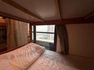 Ce lit se trouve dans un dortoir doté d'une fenêtre. dans l'établissement Haidy_hostel, à Dubaï
