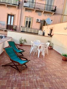 un patio con sillas, mesa y sillas en La Rizzaia casa indipendente, en Trapani