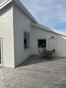 un edificio blanco con sillas y una mesa en un patio en Torbjörntorp Betel en Falköping