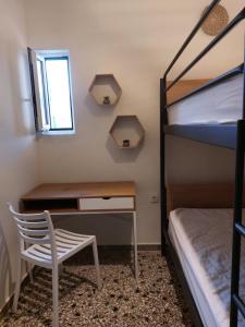 Schlafzimmer mit einem Schreibtisch und einem Etagenbett in der Unterkunft Vιtamin Sea apartment 8, Απολαυστική διαμονή στον Αλμυροπόταμο! in Almiropótamos