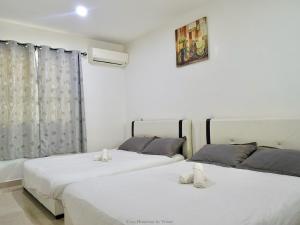 two beds in a room with white walls at Ipoh Cozy Homestay for 10-13pax in Ipoh