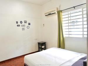 a white bedroom with a bed and a window at Ipoh Cozy Homestay for 10-13pax in Ipoh