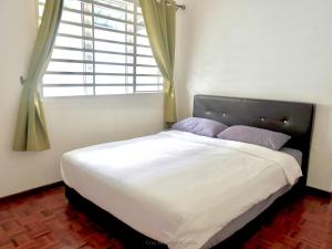 a bedroom with a large bed with a window at Ipoh Cozy Homestay for 10-13pax in Ipoh
