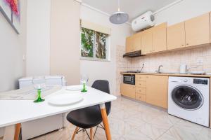 a kitchen with a table and chairs and a washing machine at City Life Marina apartment No.22 in Ampavris