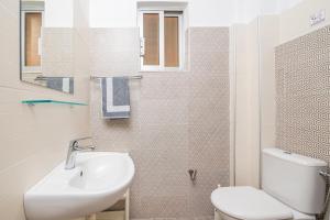 a white bathroom with a sink and a toilet at City Life Marina apartment No.22 in Ampavris