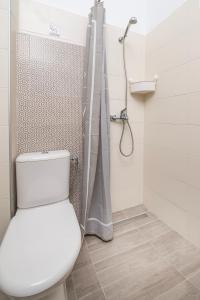 a bathroom with a toilet and a shower at City Life Marina apartment No.22 in Ampavris