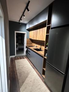 uma cozinha com um frigorífico preto e um lavatório em Amazon House 8 em Tirana