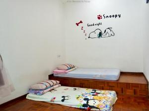 two twin beds in a room with a sticker on the wall at Ipoh Cozy Homestay for 10-13pax in Ipoh +6 photos