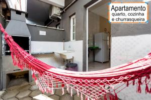 a red hammock in a room with a kitchen at Jardim do Mar suites in Ubatuba