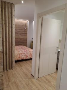 una camera con letto e parete in legno di Monolocale La Rosa a Levico Terme