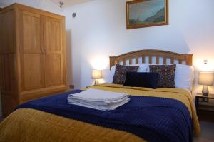 1 dormitorio con 1 cama con toallas en The Stable - rural retreat, perfect for couples en Taunton