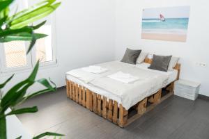 a bedroom with a bed with white sheets and a plant at SurfersResidence Apartments in Tarifa