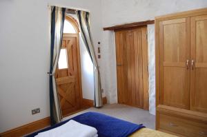 a bedroom with a bed and a wooden door at The Stable - rural retreat, perfect for couples in Taunton