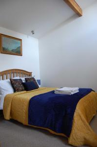 1 dormitorio con 1 cama con manta azul en The Stable - rural retreat, perfect for couples en Taunton
