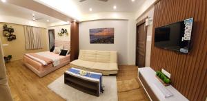 a hotel room with a bed and a television at PANTHASHALA Dooars in Lataguri