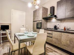 a dining room with a table and chairs in a kitchen at La Casa Bianca in Vercelli