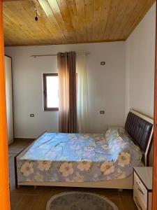 ein Schlafzimmer mit einem Bett mit Blumen darauf in der Unterkunft Bert-House close to the sea in Lezha