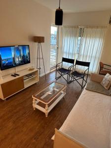 a living room with a couch and a tv at San Telmo Luminoso & Cozy Ayres del Lezama in Buenos Aires