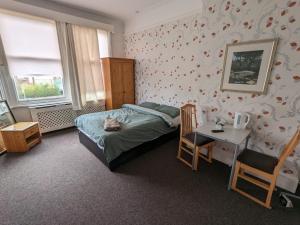 a bedroom with a bed and a desk and a table at OYO Ormsby Townhouse in Middlesbrough