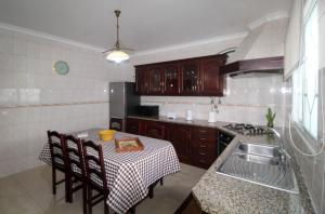 a kitchen with a table and a stove and a sink at Casa do Lavrador in Ponta Delgada