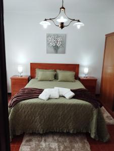 a bedroom with a bed with two towels on it at Casa do Lavrador in Ponta Delgada