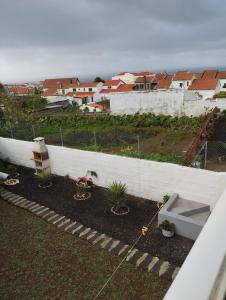 a backyard with plants and a white fence at Casa do Lavrador in Ponta Delgada