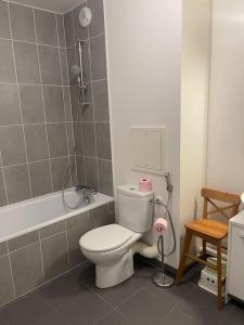 a bathroom with a white toilet and a bath tub at 3 pièces avec belle terrasse et vue dégagée. in Suresnes