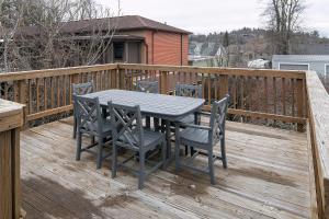 a wooden deck with a table and chairs on it at The Ridgeway Inn in Blowing Rock