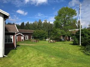 einen Hof mit Picknicktischen und ein Haus in der Unterkunft Vehkaniemen Lomatila in Pohjaslahti